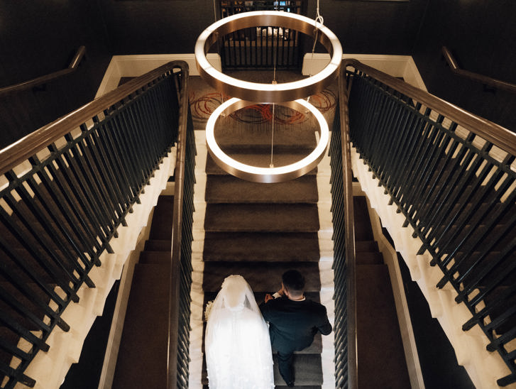 View from above of bride and groom walking up stairs